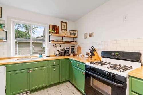 Your charming kitchen features vibrant green cabinets, warm wood counters, and everything you need to create memorable meals during your stay.