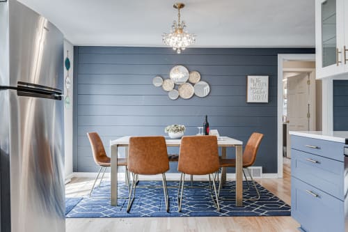 Your elegant dining space features leather chairs, crystal chandelier, and stylish blue accent wall—perfect for memorable meals together.