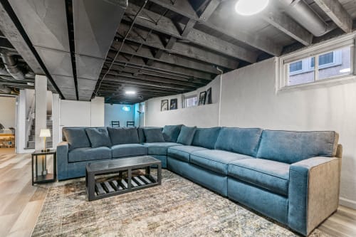 Sink into this spacious sectional sofa in your own cozy basement living area, perfect for movie nights and relaxation.