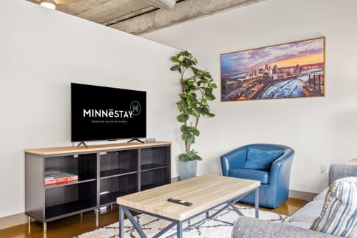 Relax in your stylish living area with exposed beam ceilings, modern TV setup, and cozy seating perfect for unwinding after exploring the city.