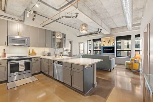 Your modern loft kitchen boasts sleek stainless appliances, spacious island, and industrial charm with exposed ceilings and abundant natural light.