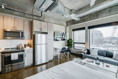 Your sleek urban loft combines industrial charm with modern comfort, featuring a full kitchen and city views for memorable stays.
