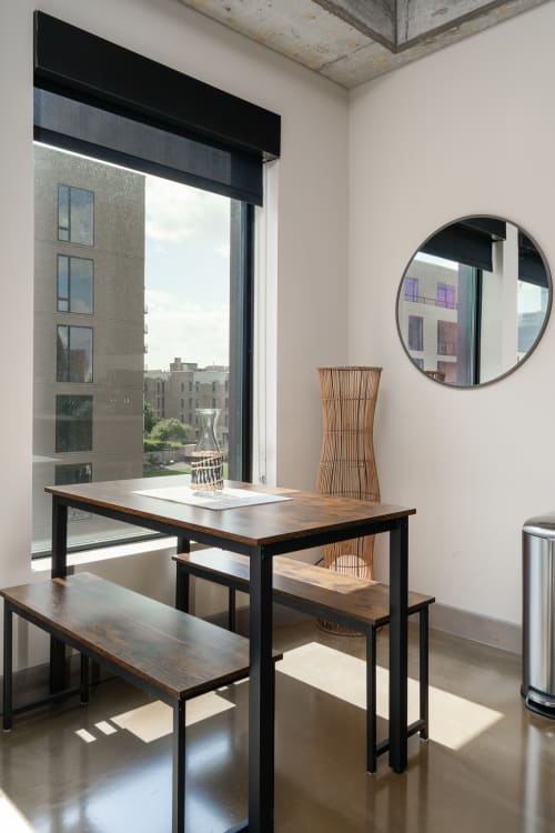 Enjoy morning coffee at your sleek dining table with inspiring city views through floor-to-ceiling windows.
