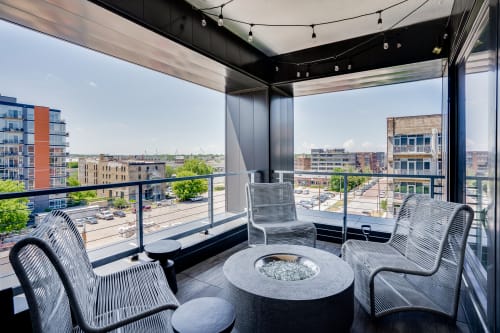 Unwind on your private terrace with stylish seating and a cozy fire table while enjoying expansive city views through floor-to-ceiling windows.