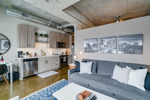 Relax in your modern loft with exposed concrete ceilings, fully equipped kitchen, and comfortable seating area perfect for unwinding after exploring the city.