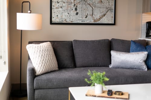 Sink into your comfortable sofa with plush pillows and warm lighting, where the local Minneapolis map above adds a personal touch to your relaxing retreat.