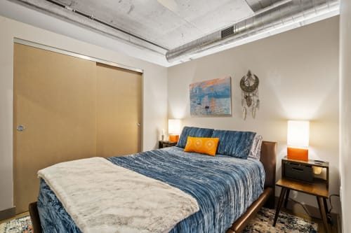 Sink into your comfortable bed surrounded by modern industrial charm and artistic touches for a restful night's sleep.