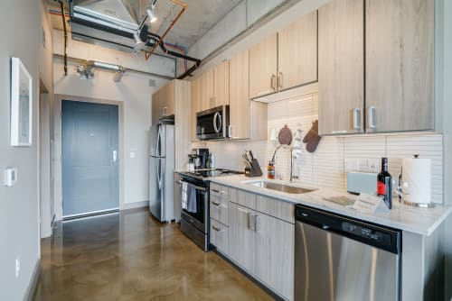 Your modern kitchen awaits with sleek appliances and warm wood cabinets, perfect for preparing meals in style.