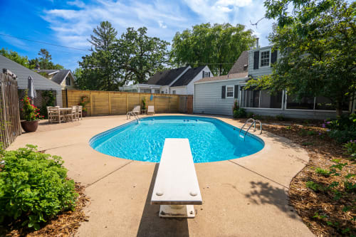 Dive into your private backyard oasis with this sparkling pool surrounded by lush landscaping and peaceful residential charm.