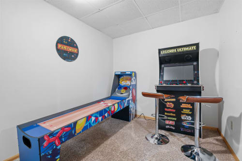 Challenge your friends to classic arcade games in your private game room, featuring vintage pinball and multi-game console.
