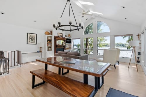 Relax in your stunning open-concept living space with soaring ceilings and panoramic water views through floor-to-ceiling windows.