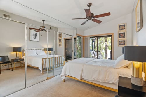 Your spacious bedroom offers modern comfort with crisp linens, warm lighting, and serene garden views through sliding doors.