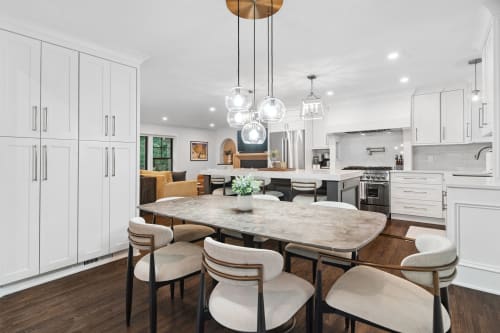 Your stunning open-concept kitchen flows seamlessly into the dining area, where gleaming pendant lights illuminate marble surfaces and premium appliances.
